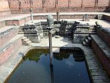 Kathmandu Bhaktapur 05-1 Bhaktapur Durbar Square Naga Pokhari The Naga Pokhari (Snake Pond) in the Palace of 55 Windows in Bhaktapur�s Durbar Square is a 17C royal water tank encircled by a writhing stone cobra. The nagas rise up on scaled pillars.